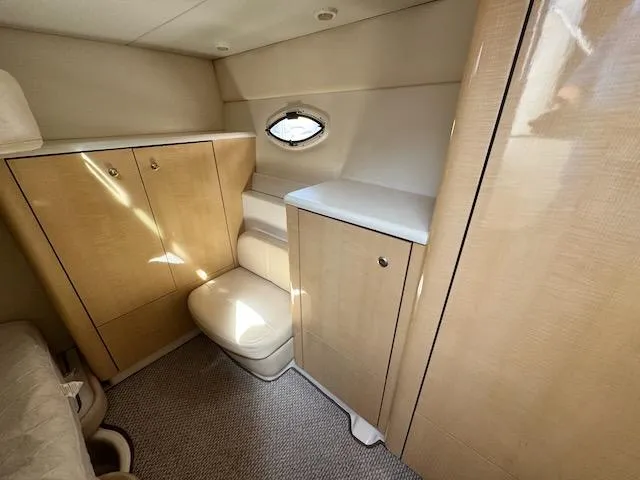 Slide: The Image of 2001 Maxum 3500 SCR cabin interior with light wood cabinetry and compact seating. - 38