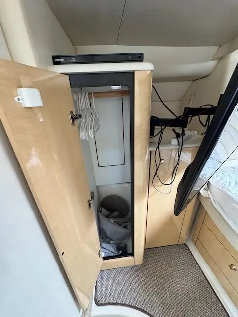 Slide: The Image of 2001 Maxum 3500 SCR cabin closet with hangers and TV setup. - 43