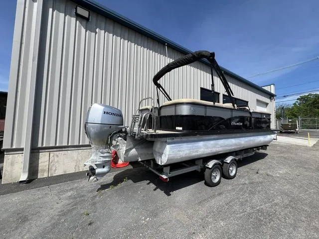 Slide: The Image of 2021 Manitou 23 Aurora LE VP pontoon boat with Honda outboard motor on trailer. - 2