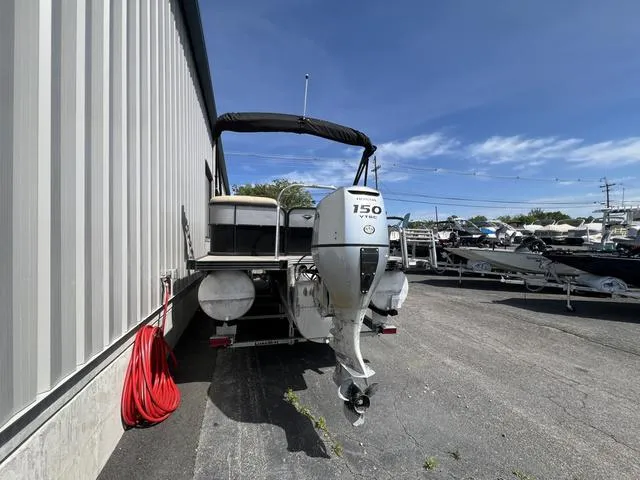 Slide: The Image of 2021 Manitou 23 Aurora LE VP pontoon boat with 150 HP engine, parked outdoors. - 3