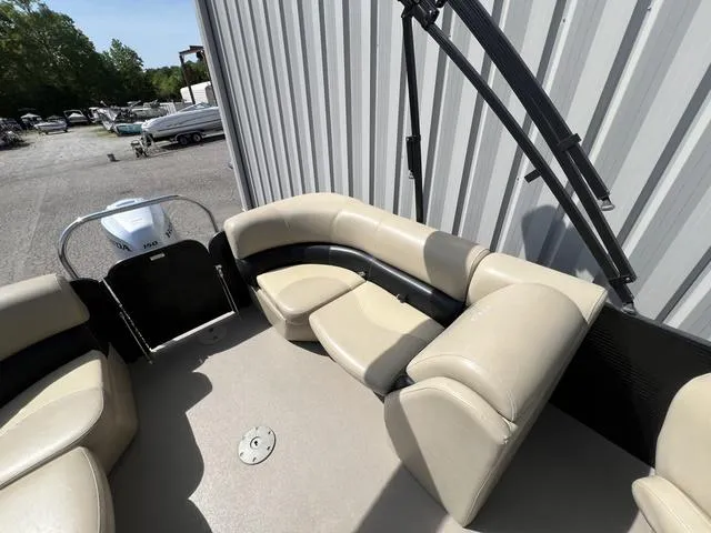 Slide: The Image of 2021 Manitou 23 Aurora LE VP pontoon boat with beige seating, docked outdoors. - 7