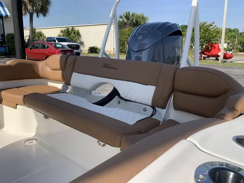Slide: The Image of 2025 Pioneer ISLANDER 202 boat interior with brown and white seating, outdoor setting. - 13