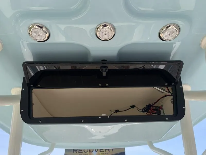 Slide: The Image of 2025 Pioneer ISLANDER 202 boat console with open storage compartment and three overhead lights. - 16