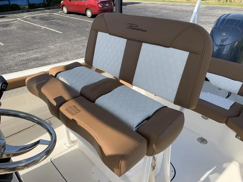 Slide: The Image of 2025 Pioneer ISLANDER 202 boat seats with brown and white upholstery in a parking lot. - 19