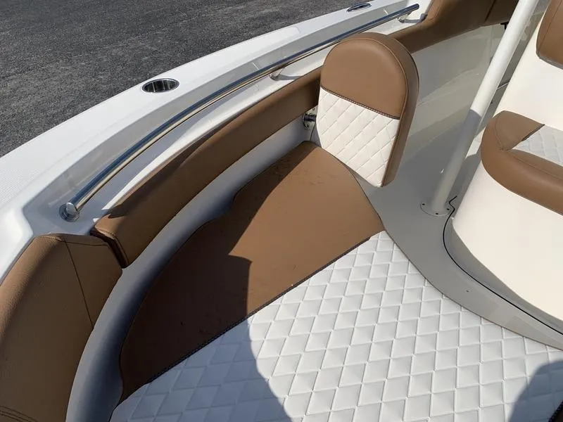 Slide: The Image of 2025 Pioneer ISLANDER 202 boat interior with brown and white cushioned seating. - 30