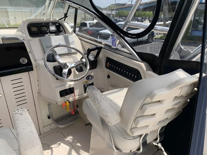 Slide: The Image of 2006 Grady-White 258 Journey boat cockpit with steering wheel and control panel. - 17