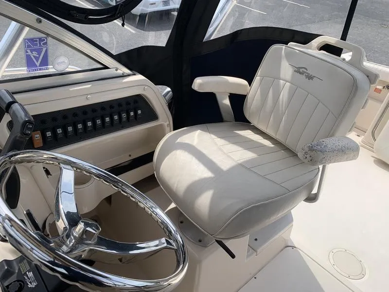 Slide: The Image of Captain's seat and helm of 2006 Grady-White 258 Journey boat, featuring steering wheel and control panel. - 20