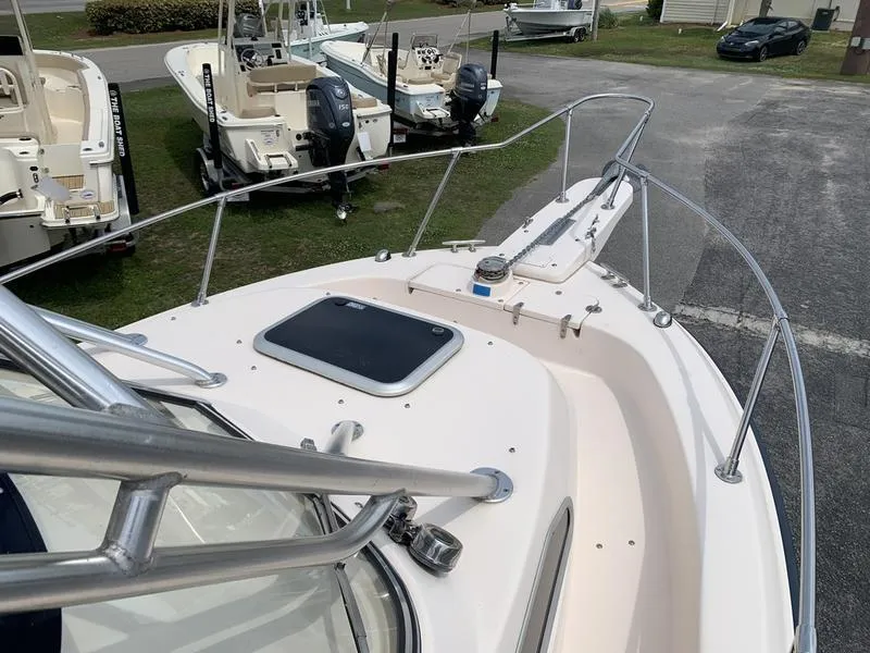 Slide: The Image of 2006 Grady-White 258 Journey boat deck, featuring railing and hatch, parked among other boats. - 27