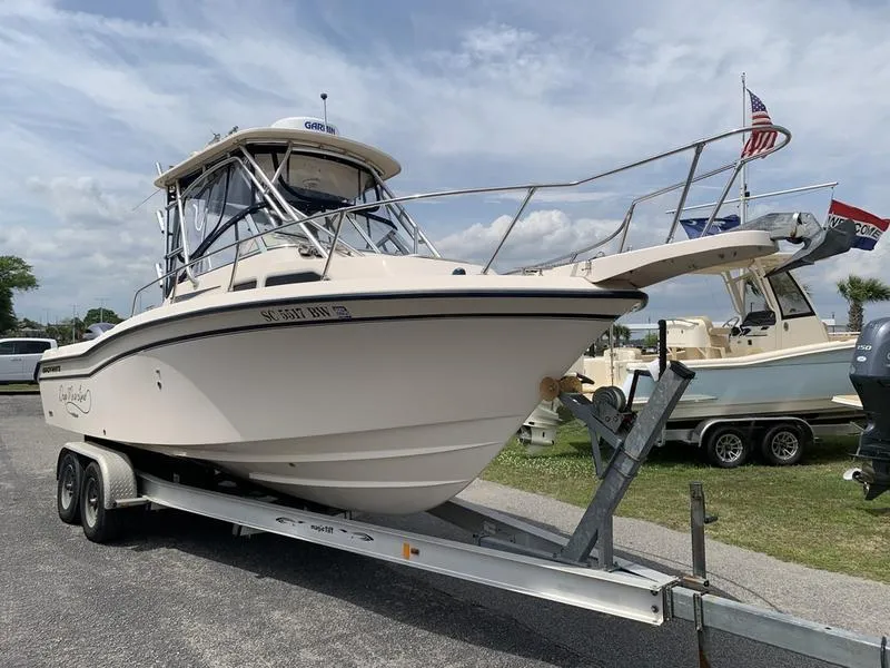 Slide: The Image of 2006 Grady-White 258 Journey boat on trailer, parked outdoors under cloudy sky. - 4
