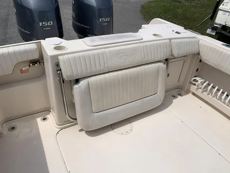 Slide: The Image of 2006 Grady-White 258 Journey boat interior with twin 150 engines, featuring cushioned seating. - 9