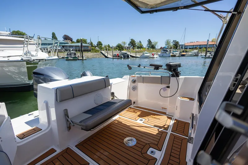 Slide: The Image of 2019 Cutwater C-24 Coupe boat with spacious deck, docked at marina. - 2
