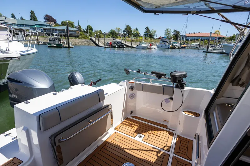 Slide: The Image of 2019 Cutwater C-24 Coupe boat interior with wooden deck, docked at a marina. - 3