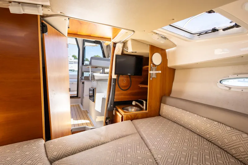 Slide: The Image of 2019 Cutwater C-24 Coupe interior with cozy cabin, TV, and natural light. - 9
