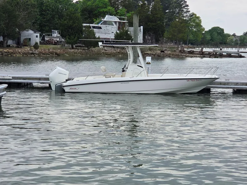 Slide: The Image of 2019 Boston Whaler 240 Dauntless boat docked on a calm lake. - 0
