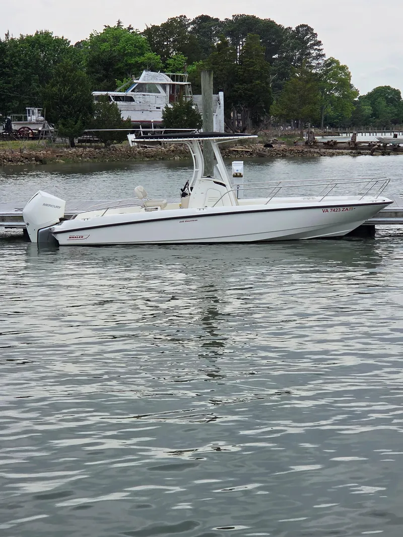 Slide: The Image of 2019 Boston Whaler 240 Dauntless boat docked on calm water. - 1