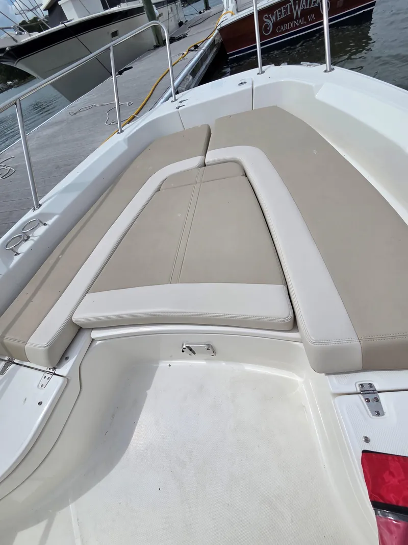 Slide: The Image of 2019 Boston Whaler 240 Dauntless boat with beige seating, docked by the water. - 20