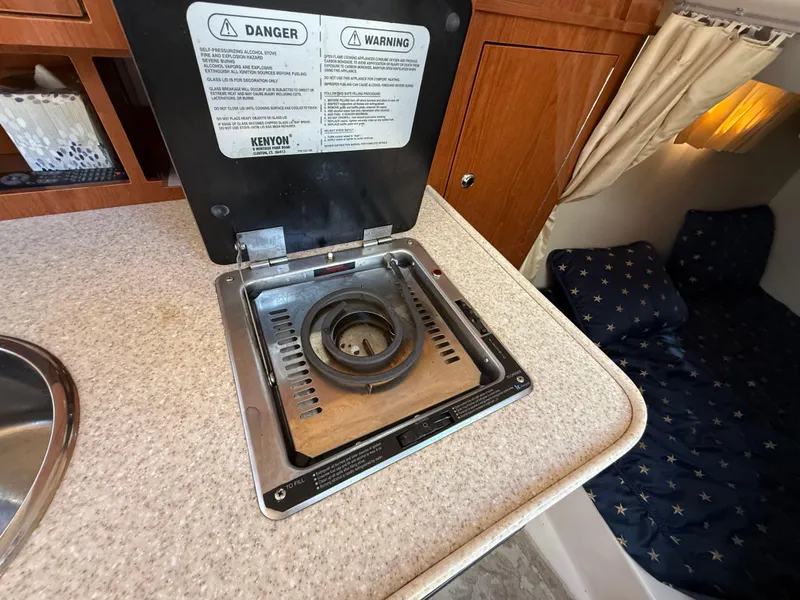 Slide: The Image of 2007 Regal 2860 Window Express boat interior with stove and cozy cabin area. - 16