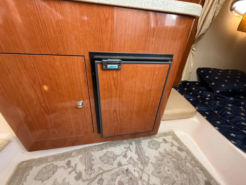 Slide: The Image of 2007 Regal 2860 Window Express interior with wood cabinetry and compact fridge. - 18