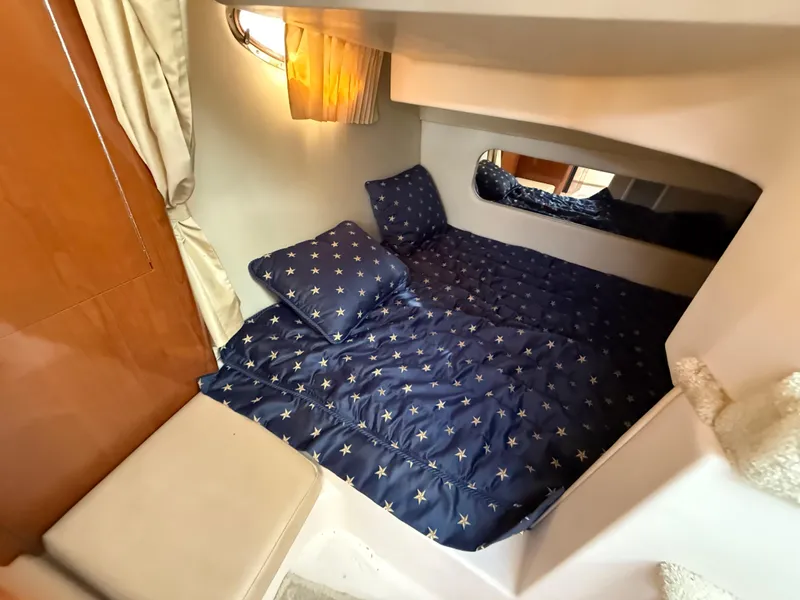 Slide: The Image of 2007 Regal 2860 Window Express cabin with star-patterned bedding. - 9