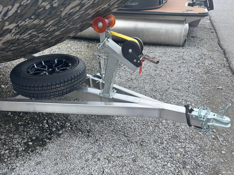Slide: The Image of Trailer hitch and spare tire of 2025 Avid 20CC Rogue boat on gravel. - 18