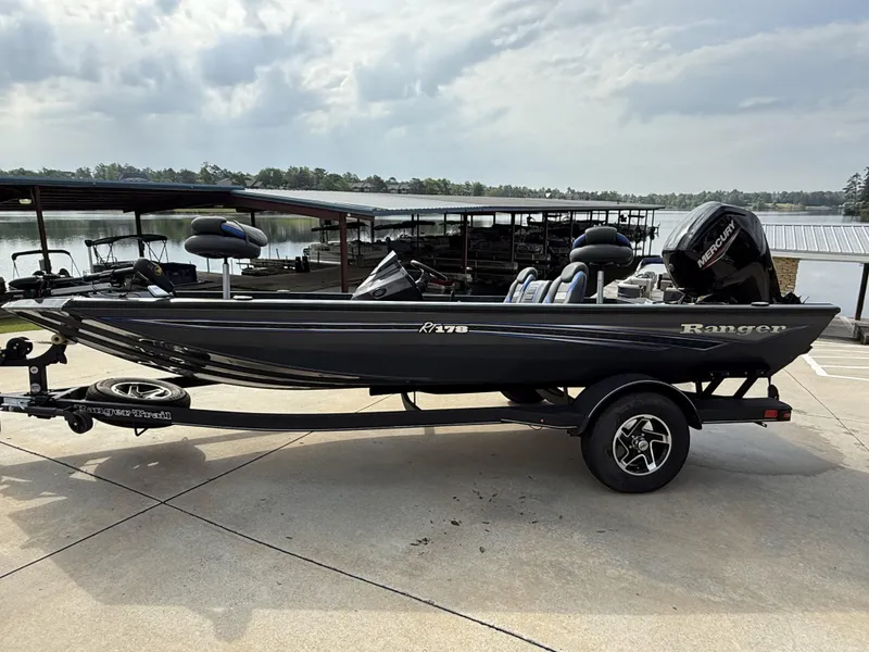 Slide: The Image of 2022 Ranger RT178 boat on trailer by a lake under cloudy sky. - 1