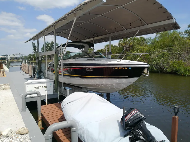 Slide: The Image of 2008 Formula 310 Sun Sport boat docked under canopy on a sunny day. - 2