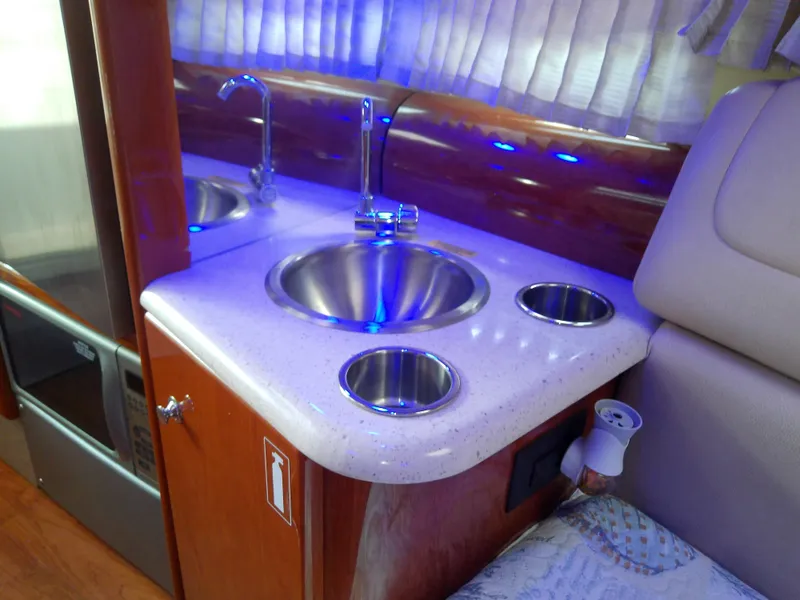 Slide: The Image of 2008 Formula 310 Sun Sport interior with sink, countertop, and ambient blue lighting. - 33