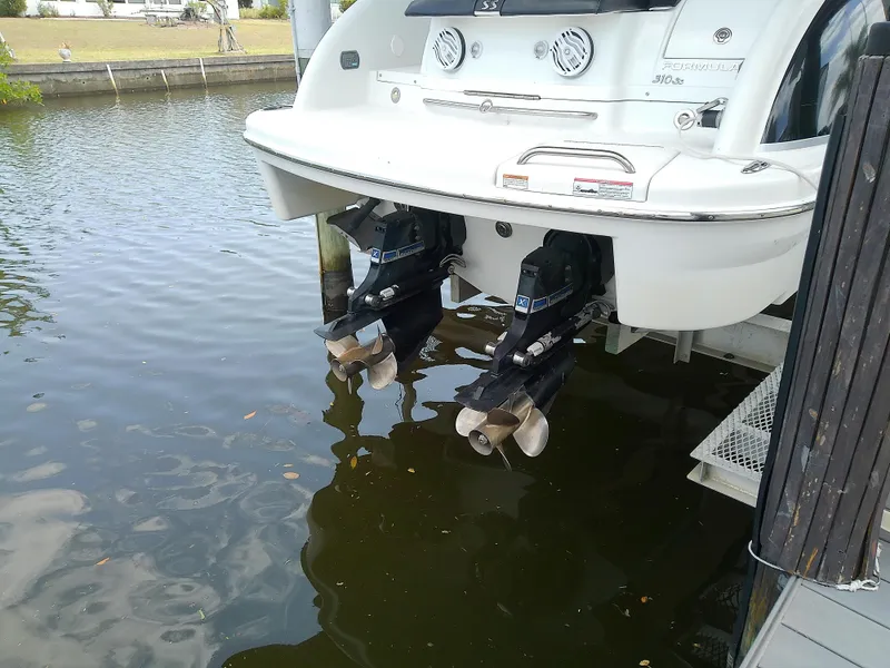 Slide: The Image of 2008 Formula 310 Sun Sport boat with dual outboard motors docked in calm water. - 5