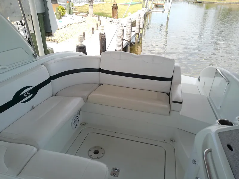 Slide: The Image of 2008 Formula 310 Sun Sport boat interior with white seating near a dock. - 12
