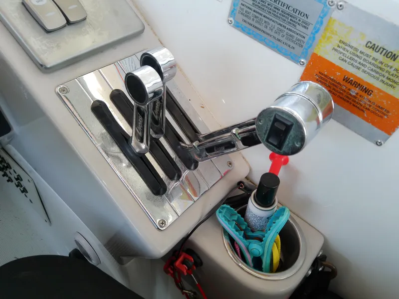 Slide: The Image of 2008 Formula 310 Sun Sport boat controls with throttle levers and storage compartment. - 23
