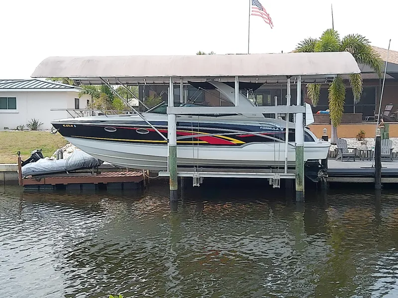 Slide: The Image of 2008 Formula 310 Sun Sport boat docked under a canopy by the water. - 0