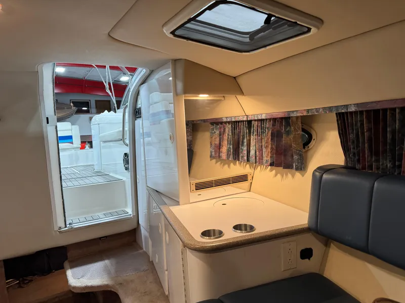 Slide: The Image of Interior of a 1998 Formula 330 SS boat, featuring a compact kitchenette and seating area. - 13
