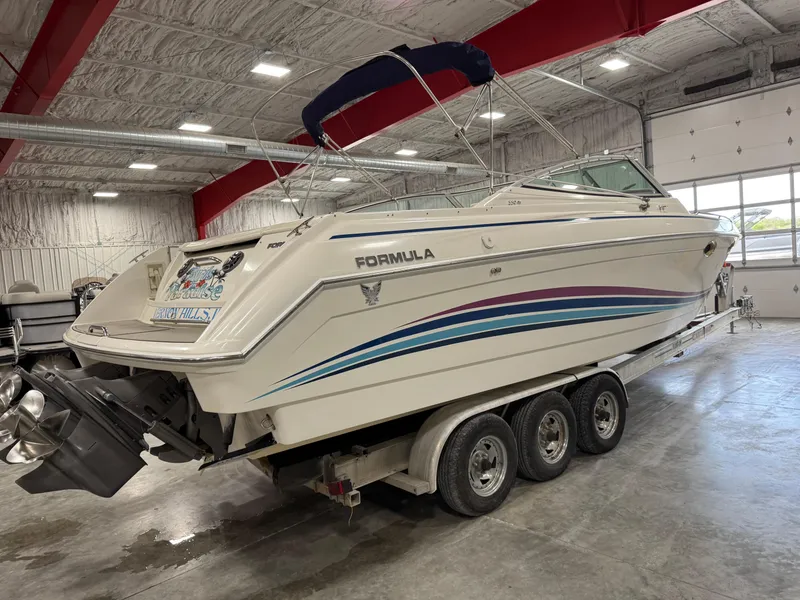 Slide: The Image of 1998 Formula 330 SS boat in a garage, featuring a sleek design and triple-axle trailer. - 3