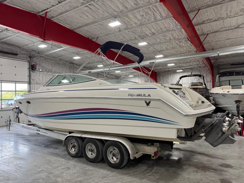 Slide: The Image of 1998 Formula 330 SS boat on a trailer in a spacious indoor storage facility. - 4