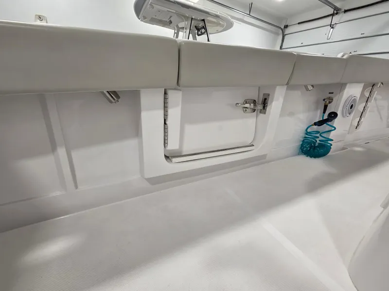 Slide: The Image of 2023 Jupiter 30 boat interior with storage compartments and coiled hose. - 12