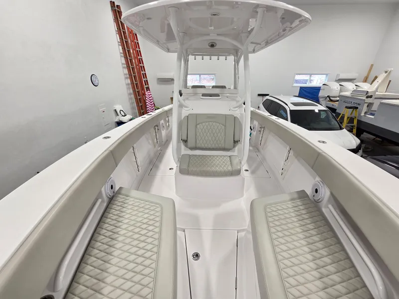 Slide: The Image of 2023 Jupiter 30 boat interior with cushioned seating and modern design in a showroom. - 13