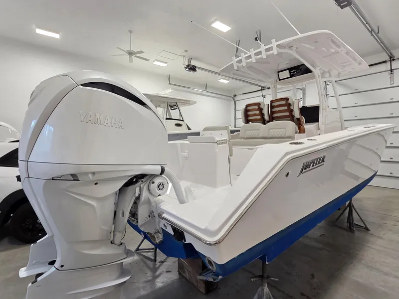 Slide: The Image of 2023 Jupiter 30 boat with Yamaha engine in a garage setting. - 2
