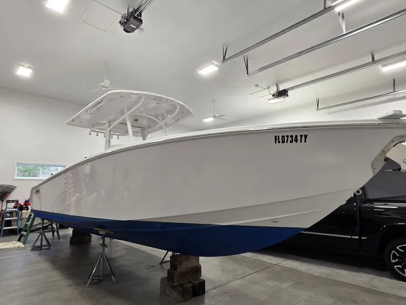 Slide: The Image of 2023 Jupiter 30 boat in garage, white hull with blue bottom, registration FL0734TY. - 20