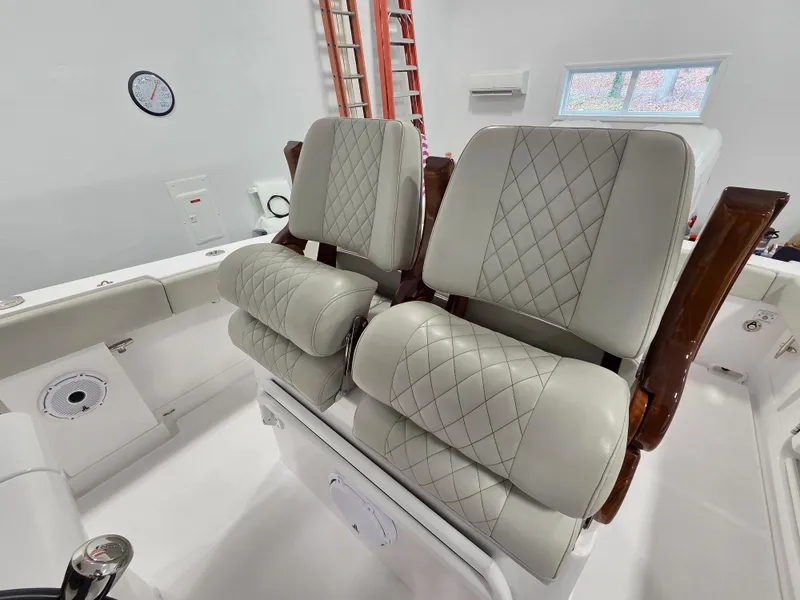 Slide: The Image of Luxurious seating on 2023 Jupiter 30 boat with quilted upholstery and wooden accents. - 5