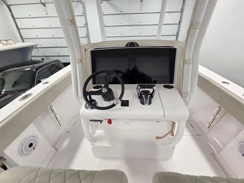 Slide: The Image of 2023 Jupiter 30 boat helm with steering wheel and controls in a garage setting. - 6
