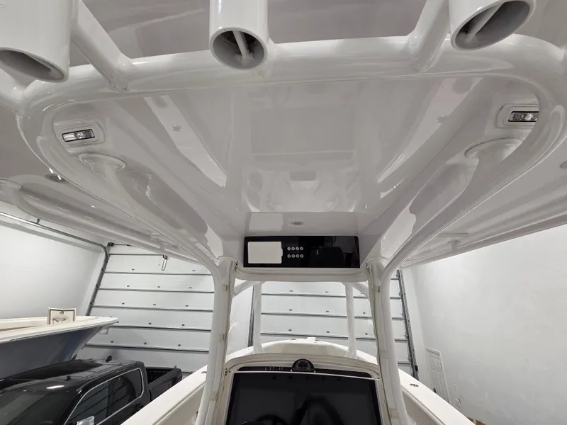 Slide: The Image of 2023 Jupiter 30 boat interior, featuring sleek white design and modern equipment in a garage setting. - 7