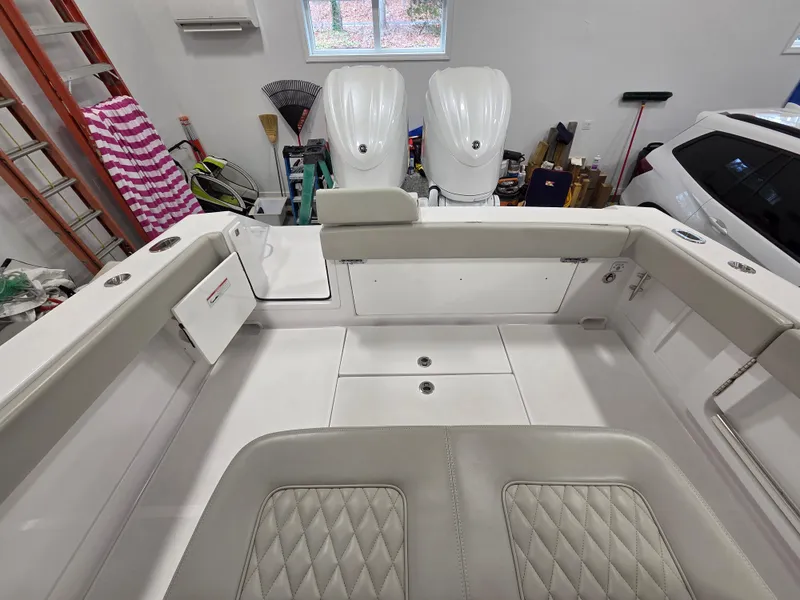 Slide: The Image of Interior view of a 2023 Jupiter 30 boat, featuring sleek seating and dual outboard motors. - 9