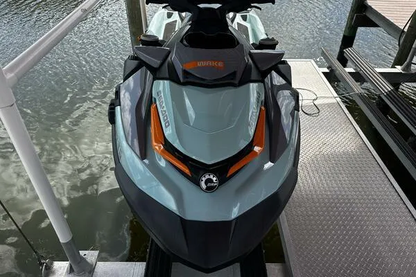 Slide: The Image of 2022 Sea-Doo Wake Pro 230 jet ski docked by the water. - 0