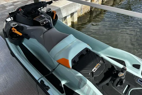 Slide: The Image of 2022 Sea-Doo Wake Pro 230 jet ski docked by the water. - 1