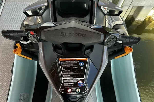 Slide: The Image of 2022 Sea-Doo Wake Pro 230 handlebars and dashboard, featuring control buttons and safety instructions. - 12