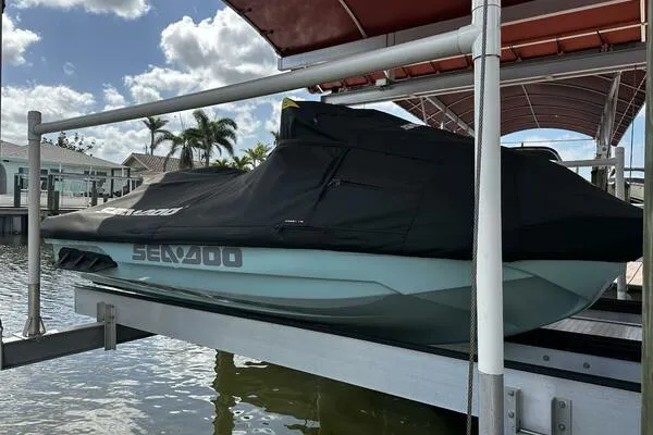 Slide: The Image of 2022 Sea-Doo Wake Pro 230 jet ski covered, docked by waterfront homes. - 16