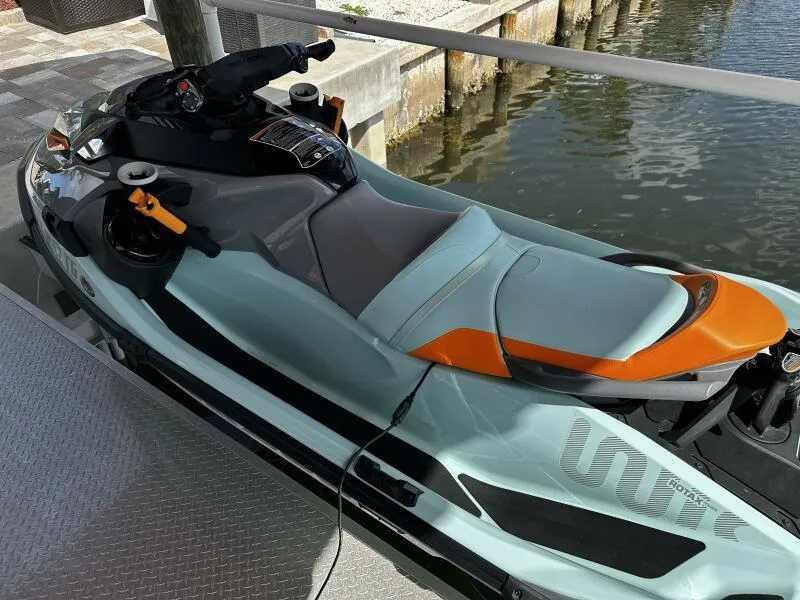Slide: The Image of 2022 Sea-Doo Wake Pro 230 jet ski docked by the water. - 2