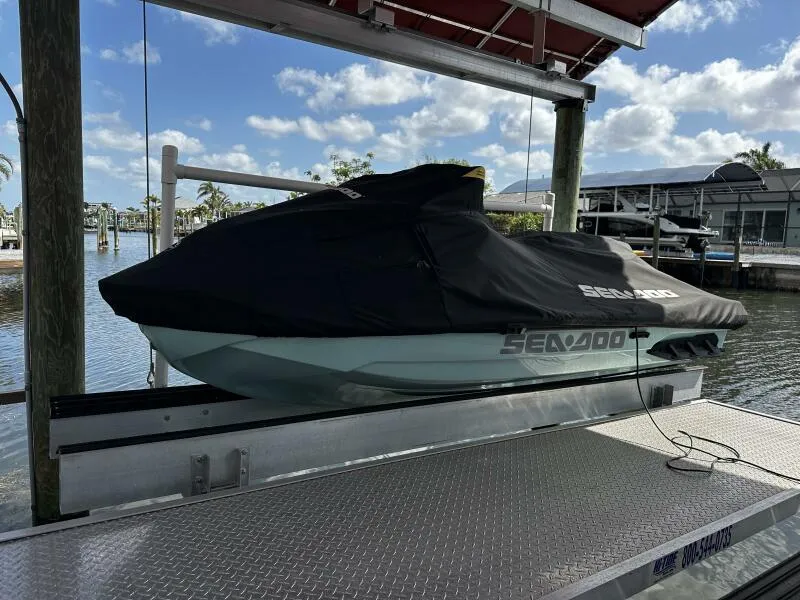 Slide: The Image of 2022 Sea-Doo Wake Pro 230 jet ski covered on a dock lift by the water. - 8
