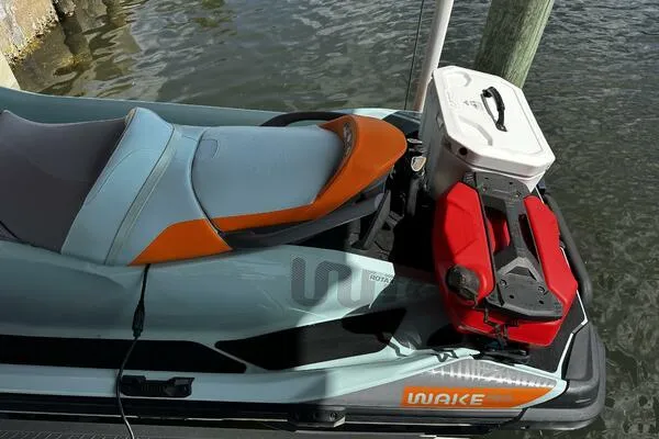 Slide: The Image of 2022 Sea-Doo Wake Pro 230 jet ski docked, featuring a sleek design and storage accessories. - 9