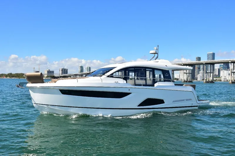 Slide: The Image of 2022 Sealine C430 #42 yacht cruising on a sunny day with city skyline backdrop. - 11